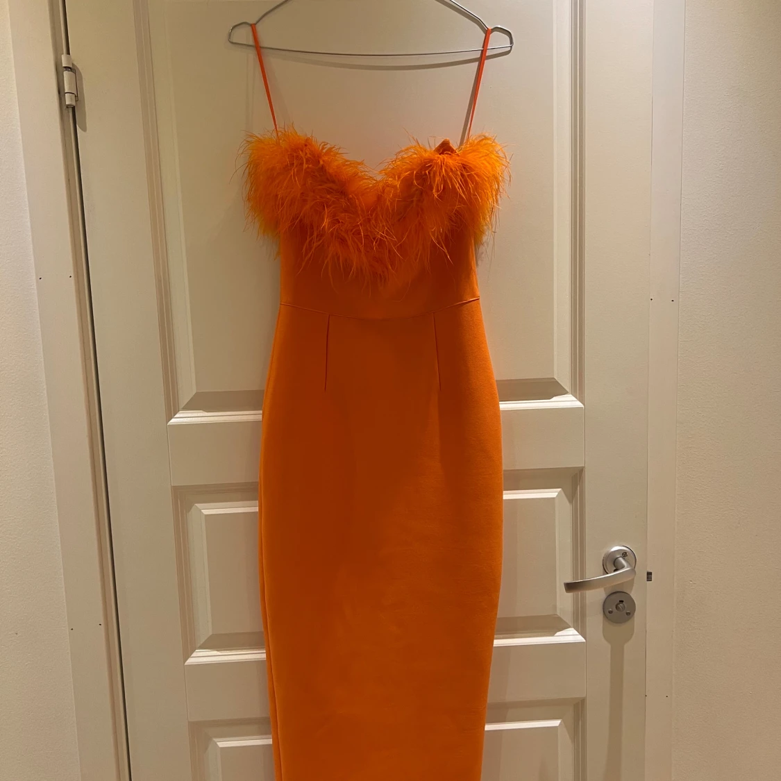 Orange klänning med fjäderdetaljer - 92