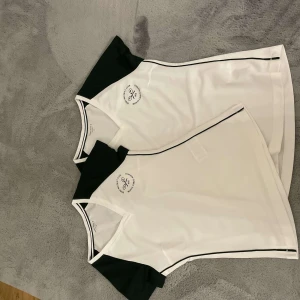 Vit och svart tenniströja från Björn Borg - Säljer två snygga vita tenniströjor från Björn Borg med svarta detaljer och krage. Perfekt för en match på banan eller en sportig look. Tröjan är i helt nytt skick och aldrig använt och har en stilren design med logga på bröstet. En är i xs och den andra är i medium