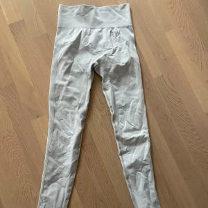 Grå leggings från RW - Säljer ett par grå leggings från RW i mycket bra skick. De är högmidjade och har en tight passform. Materialet är stretchigt och bekvämt, men contoring av rumpan blir dem väldigt snygga på. Super fint skick, använda en gång men som nya. Storlek XS men passar även en S.