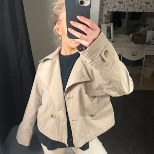 Jacka - Säljer en snygg beige jacka från Cubus! Den har en croppad stil med knappar framtill och långa ärmar. Perfekt för vår och höst! 🧥✨storlek 158, men sitter som en xs/s ☺️