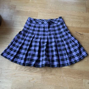 Lila rutig kjol från h&m - Säljer en superfin lila rutig kjol från Divided. Den har en klassisk A-linjeform och är perfekt för både vardag och fest. Kjolen är i mycket bra skick och har en bekväm passform. 💜