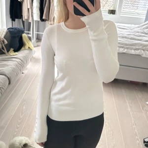 Vit långärmad tröja från Zara - Säljer en superfin vit långärmad tröja från Zara i storlek S. Den är i mycket bra skick och har snygga knappar på ärmarna som en extra detalj. Perfekt för både höst och vår! Passar till allt och är riktigt bekväm. 