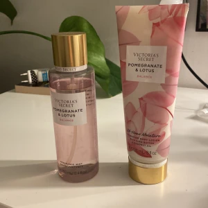 Victoria's Secret Pomegranate & Lotus Set - Säljer ett set med Victoria's Secret Pomegranate & Lotus. Inkluderar en Fragrance Mist och en Hydrating Body Lotion. Doften är en härlig mix av granatäpple och lotus, perfekt för att känna sig fräsch hela dagen. Lotionen ger 24-timmars återfuktning med sheasmör och kokosolja. Båda produkterna har en elegant design med rosa toner och guldiga detaljer. De är knappt använda och köptes i usa för en månad sen