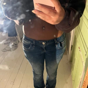 Blå jeans från LTB - Säljer ett par snygga blå jeans från LTB i storlek 26/32. De är lågmidjade med en bootcut-stil. Jeansen är i bra skick. Perfekta för både vardag och fest!