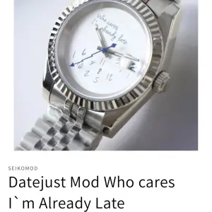 Säljer en unik Seikomod Datejust-modell med texten 'Who cares I`m Already Late' på urtavlan. Klockan har en silverfärgad boett och armband, med en vit urtavla och blå visare. Perfekt för den som vill ha en stilren men humoristisk accessoar.