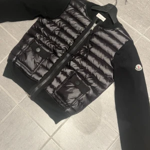Moncler cardigan | svart dam-modell  - Säljer nu en snygg svart moncler cardigan  från Moncler i mycket bra skick. Jackan har en quiltad design med dragkedja och två fickor med knappar framtill. Perfekt att ha som en tunnare jacka nu! 🖤lappar tillkommer☺️