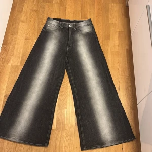 Svarta vida från weekday x Cheap Monday - Säljer ett par feta svarta vida jeans från weekday x Cheap Monday helt nya och enbart använda vid provning.  De har en cool, tvättad look och är Mid waist med knapp och dragkedja fram. Perfekta för en avslappnad stil och passar till alla säsonger. Storleken är 30/32. 