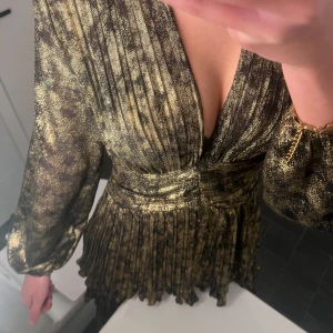 Glittrig klänning med volangdetaljer - jätte fin svart guldig klänning från zara, köpt förra året innan nyår och har endast använt en gång. säljer då den ej kommer till användning tyvärr🥰🥰 