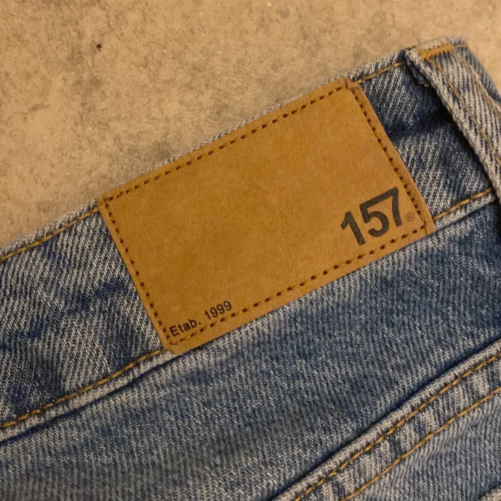 Säljer ett par snygga blå jeans från 157 i storlek XS. De har en cool, sliten look med hål på knäna och en avslappnad passform. Perfekta för en casual stil! 🕶️. Jeans & Byxor.