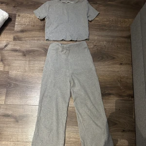 Grå sett - Säljer en supermjuk och bekväm grå sett. Den har en loose passform med vida ben och en croppad topp. Perfekt för en avslappnad dag hemma eller en chill dag ute. 