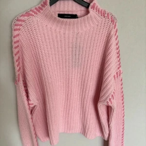 Rosa stickad tröja med unika detaljer - Säljer en superfin rosa stickad tröja från Vero Moda. Den har långa ärmar och coola öppna stickade detaljer längs axlarna. Perfekt för både höst och vår! Tröjan är i ny skick och passar perfekt för en mysig dag ute eller hemma. 💖