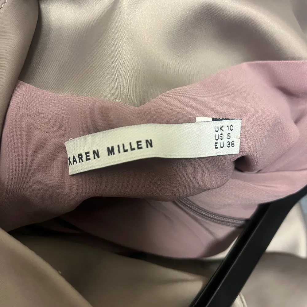 Snygg och elegant klänning från Karen Millen i en vacker beige ton. Klänningen har en unik design med asymmetriska detaljer och en oneshoulder-stil. Tillverkad i en blandning av acetat och polyamid med en liten del elastan för extra komfort. Perfekt för festliga tillfällen! Storlek 38.. Klänningar.