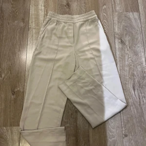 Kostymbyxor  - Säljer ett par superbekväma beige kostymbyxor . De har en elastisk midja och raka ben. 