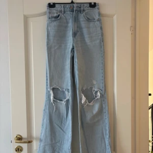 Ljusa jeans med slitningar - Säljer ett par snygga ljusblå long straight fit jeans från Stradivarius, mycket bra skick och inga skavanker!