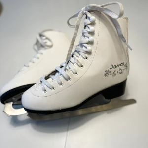 Stl 36 Vita konståkningsskridskor från Davos - Stl 36.  Vita konståkningsskridskor från Davos med klassisk snörning och dekorativt mönster på sidan. Superfint skick. Skickas mot fraktkostnad eller hämtas på Hägerstensåsen eller ök. ⛸️❄️