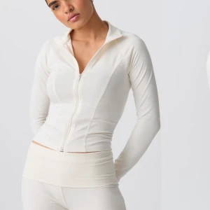 Gina Soft Touch zip jacket 💗😊 - Snygg och stilren vit långärmad tröja med dragkedja framtill. Perfekt för en sportig look eller en avslappnad dag. Tröjan har en tight passform och är tillverkad i ett mjukt och bekvämt material. På sista bilden får man se fläcken som syns på tröjan , har ingen aning vart den kommer ifrån men kanske går få bort om någon har något husmorsknep🤣 men tycker inte fläcken syns så mycket 