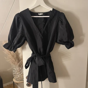 Svart topp med knyte  - säljer en topp med knyte i midjan, den ser längre ut än vad den är på (har stl xs-s). Den är i storleken S och säljs på grund av att den inte längre används. 