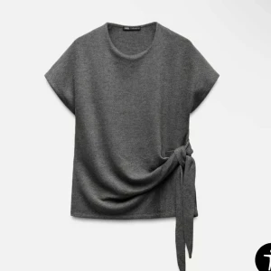 Grå stickad topp med knytning - Snygg grå topp från Zara med korta ärmar och en stilren knytning i sidan💕I storlek M men passar mig som brukar ha S💘