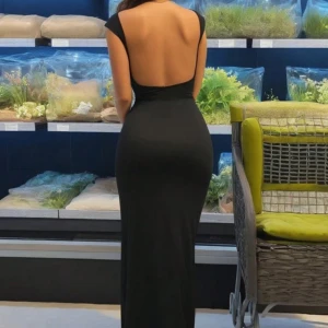 Svart långklänning med öppen rygg - Elegant svart långklänning med en stilren och sofistikerad design. Klänningen har en djup öppen rygg och är axelbandslös, vilket ger en chic look. Perfekt för speciella tillfällen. Endast tvättad, aldrig använd🖤