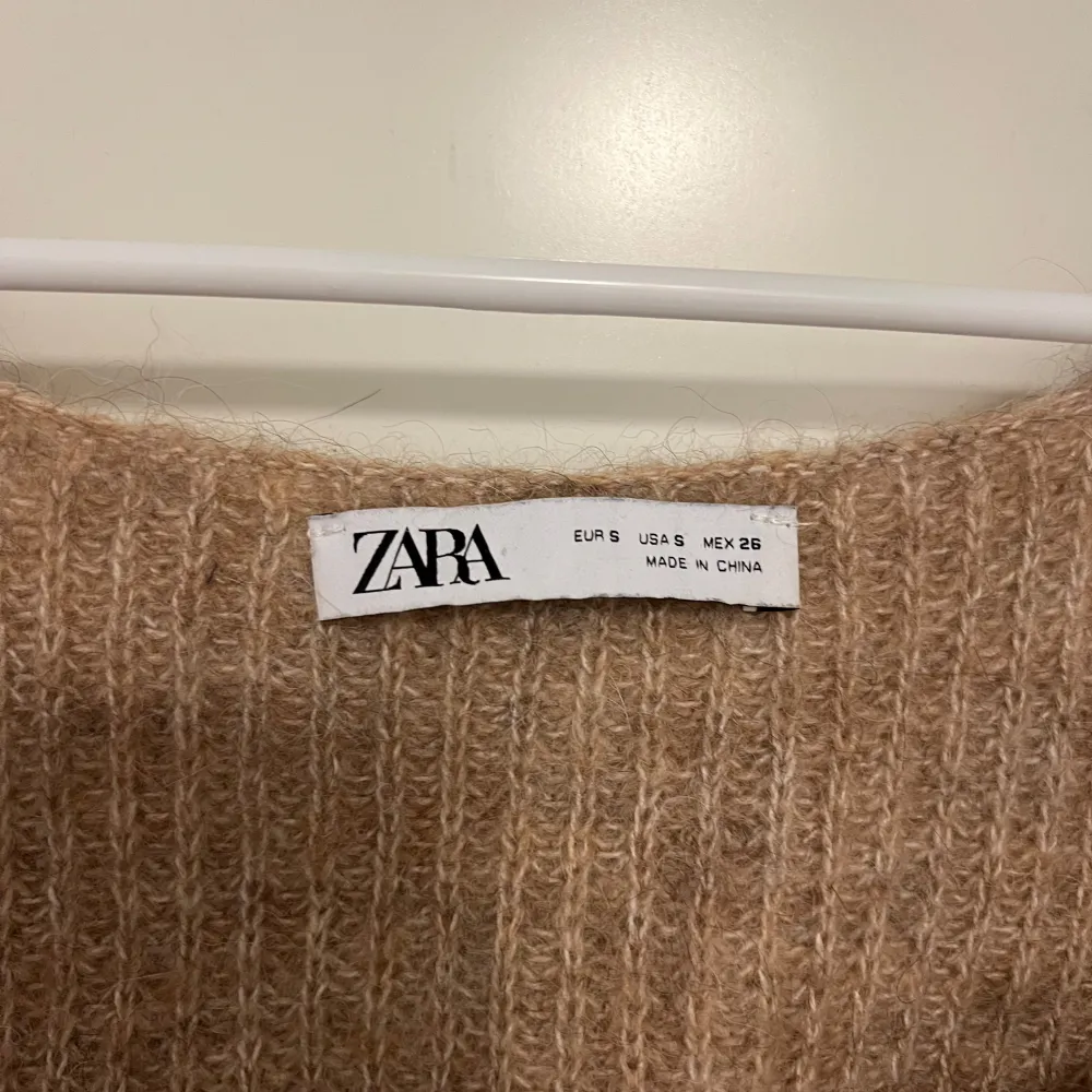 Säljer en croppad beige stickad topp från Zara. Den är väldigt mjuk och mysig samtidigt som snygg. Supersöt verkligen, har använts en del men fortfarande i bra skick. Yläosat.