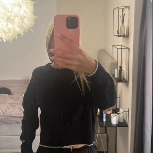 Svart ribbad tröja - Säljer en stilren svart ribbad tröja med långa ärmar. Perfekt för en avslappnad look. Tröjan har en croppad passform som ger en modern touch.