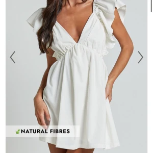 Vit klänning med volanger - Säljer en söt vit klänning med volanger och djup v-ringning. Klänningen har en öppen rygg med knytning och är perfekt för sommarens alla tillfällen och studenten! 