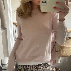 Ljusrosa långärmad tröja - Säljer en stilren ljusrosa långärmad tröja. Perfekt för en avslappnad look. Tröjan har en enkel design med rund hals och är tillverkad i ett mjukt material.