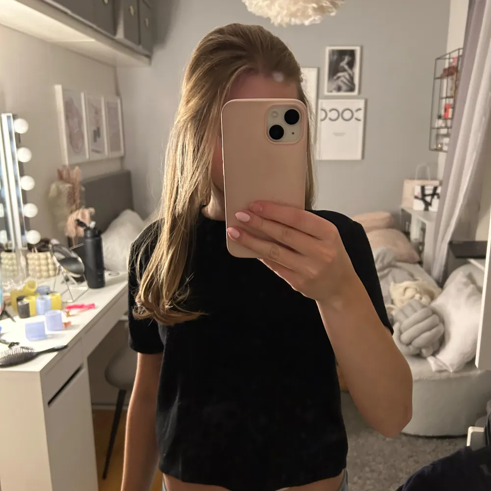 Säljer en stilren svart kortärmad topp. Perfekt för en enkel och klassisk look. Toppen har en normal passform och är tillverkad i ett mjukt material.. Yläosat.