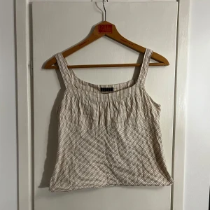 Beige och vit randig topp - Säljer en söt beige och vit randig topp köpt secondhand. Den är inte särskilt stretchig så passar nog bäst på en xs/s🌟😸🌟