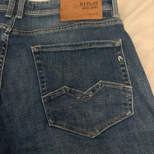 Blå jeans från Replay - Snygga blå jeans från Replay med klassisk femficksdesign och en bekväm passform. De har en dragkedja och knapp framtill samt Replay-logga på bakfickan. Perfekta för en avslappnad stil.