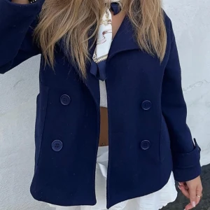 Mörkblå kappa - Snygg mörkblå skepparkavaj med dubbelknäppning och klassisk krage. Perfekt för en stilren look. Passar bra till både jeans och kjol.