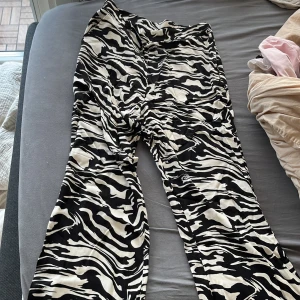 Zebramönstrade byxor - Snygga zebramönstrade byxor i svart och vitt. Byxorna har en loose passform och är perfekta för att sticka ut med sitt djärva mönster. De är tillverkade i ett bekvämt material som passar bra för olika tillfällen.