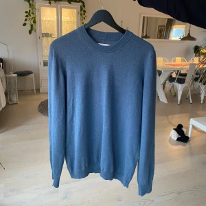 Blå tröja från Samsøe Samsøe - Snygg blå tröja från Samsøe Samsøe i en klassisk design. Tröjan har en rund halsringning och långa ärmar, perfekt för en stilren look. Passar bra till både jeans och chinos. Mycket bra skick! Storlek L men passar mer som M. Personen på bilden är 180 cm lång o väger 75 kg! Skriv vid frågor!