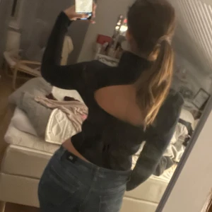 Svart ribbad tröja med öppen rygg - Säljer en svart ribbad tröja med en snygg öppen ryggdetalj. Perfekt för en utekväll eller när du vill ha något lite extra. Tröjan har långa ärmar och en tight passform som framhäver figuren. L fast passar mig som brukar ha S/M. Superbekväm och stilren! Hör av dig vid frågor💞💞