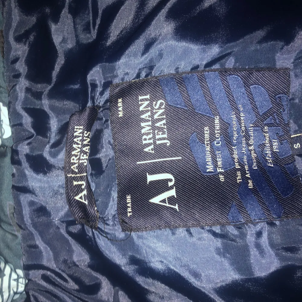 Säljer en snygg pufferjacka från Armani Jeans i storlek S. Jackan har ett coolt mönster i svart och blått med dragkedja framtill. Perfekt för höst och vinter när du vill hålla dig varm och stilren. Passar både till vardags och lite mer uppklädda tillfällen. 🖤💙. Jackor.