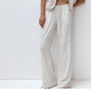 Randiga linnebyxor i beige - Grå och vitrandiga linnebyxor i storlek xs. Är korta i modellen så skulle säga att dem passar om man är under 160 cm. Bra skick