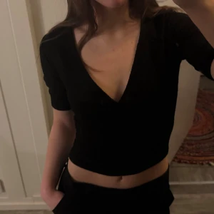 Svart omlott-topp - Superfin, Stockholmsstil, klassisk omlott-topp från BikBok i strl XS, passar även mig som brukar ha S på toppar! Tyget har textur likt bäckebölja❤️ skriv för fler bilder eller funderingar!