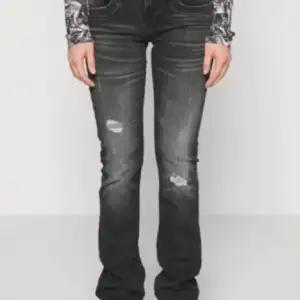 Säljer ett par svarta Lågmidjade bootcut jeans i bra skick. De har en snygg slitning på låren och knäna, Perfekta för både vardag och fest! 🖤de står storleken är w32/33