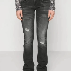 Svarta bootcut jeans - Säljer ett par svarta Lågmidjade bootcut jeans i bra skick. De har en snygg slitning på låren och knäna, Perfekta för både vardag och fest! 🖤de står storleken är w32/33