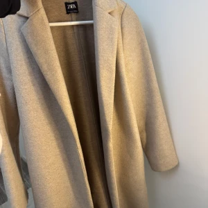 Beige kappa från ZARA - Säljer en beige kappa från ZARA i bra skick. Perfekt för höst/vinter och vår Har inte använt den så mycket då jag har andra kappor det vill jag sälja den. Priset kan diskuteras och hör gärna av dig om du har några frågor!🫶