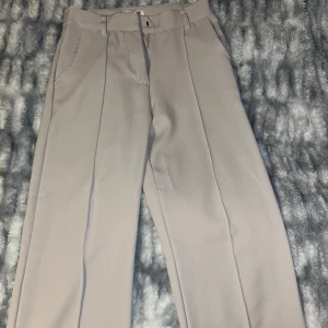 Beige byxor från Madlady - Säljer ett par stilrena beige byxor från Madlady i storlek XS. De har en klassisk design med hög midja och raka ben, perfekt för både vardag och fest. Byxorna är i mycket bra skick och har en bekväm passform. Perfekta för höst och vår! Aldrig använt!!