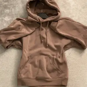 Mysig brun hoodie från Bik Bok i storlek XS. Perfekt för kyliga dagar med sin mjuka insida och praktiska ficka framtill. Den har en klassisk design med dragsko i huvan och ribbade muddar vid ärmslut och nederkant. Ett måste för höstgarderoben! 