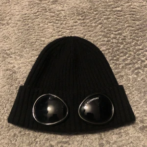 Svart mössa från C.P. Company - Säljer denna mössa från C.P. Company då den inte används. Mössan är i mycket bra skick och passar de flesta. Billigare vid snabb affär. Köparen står för frakt 