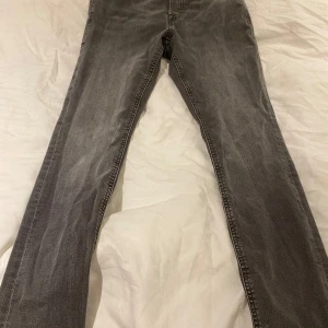 Slim/Glen Jeans från Jack & Jones - Säljer ett par grå jeans från Jack & Jones i ny skick. De har en slim passform och är perfekta för både vardag och fest. Använda 1 gång. Modellen på bilden är 166 cm lång.