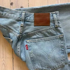 Säljer ett par klassiska ljusblå Levi's jeans i bra skick. De har en snygg vintage-look med fem fickor och knappgylf. 