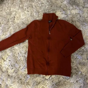 Rostfärgad ulltröja från Lawrence Grey - Säljer en snygg rostfärgad tröja från Lawrence Grey i 100% merinoull. Perfekt för kyliga dagar med sin dragkedja och långa ärmar. Tröjan är i storlek M och är använde få gånger!
