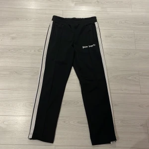 Palm Angels Trackpants Svart byxor - Ett par byxor från Palm Angels. Byxorna är äkta och äkthetsbevis o påse finns. Byxorna är i väldigt bra skick o passar till allting. Extremt bekväma o säljs till ett väldigt bra pris. Passar både till M o L. Hör av er vid fler frågor eller liknande🤙🏼