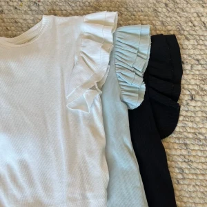 Tröja med volangaxel - Tre tröjor med volangaxlar som tyvärr inte används längre. En för 40 kr eller 3 för 100kr💞 Den svarta är i stl 158/164 och dom andra två är i 146/152. Köparen står för frakten.💘 