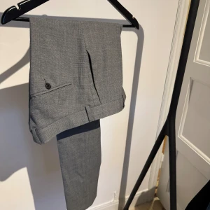 J. Lindeberg kostymbyxor - Kostymbyxor från Johan Lindeberg. Skick 7/10, fina och fräscha men har ett litet hål som kan behöva sys igen, se bild. 