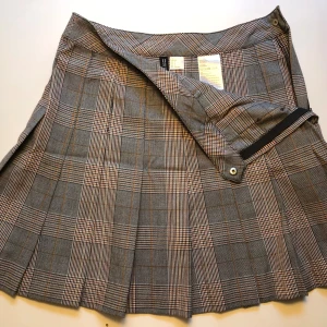 Kort plisserad kjol - Kort plisserad kjol, grårutig, slk 36